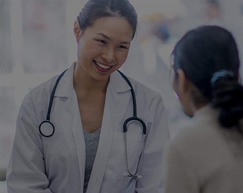 Physician smiling and talking to a patient.
